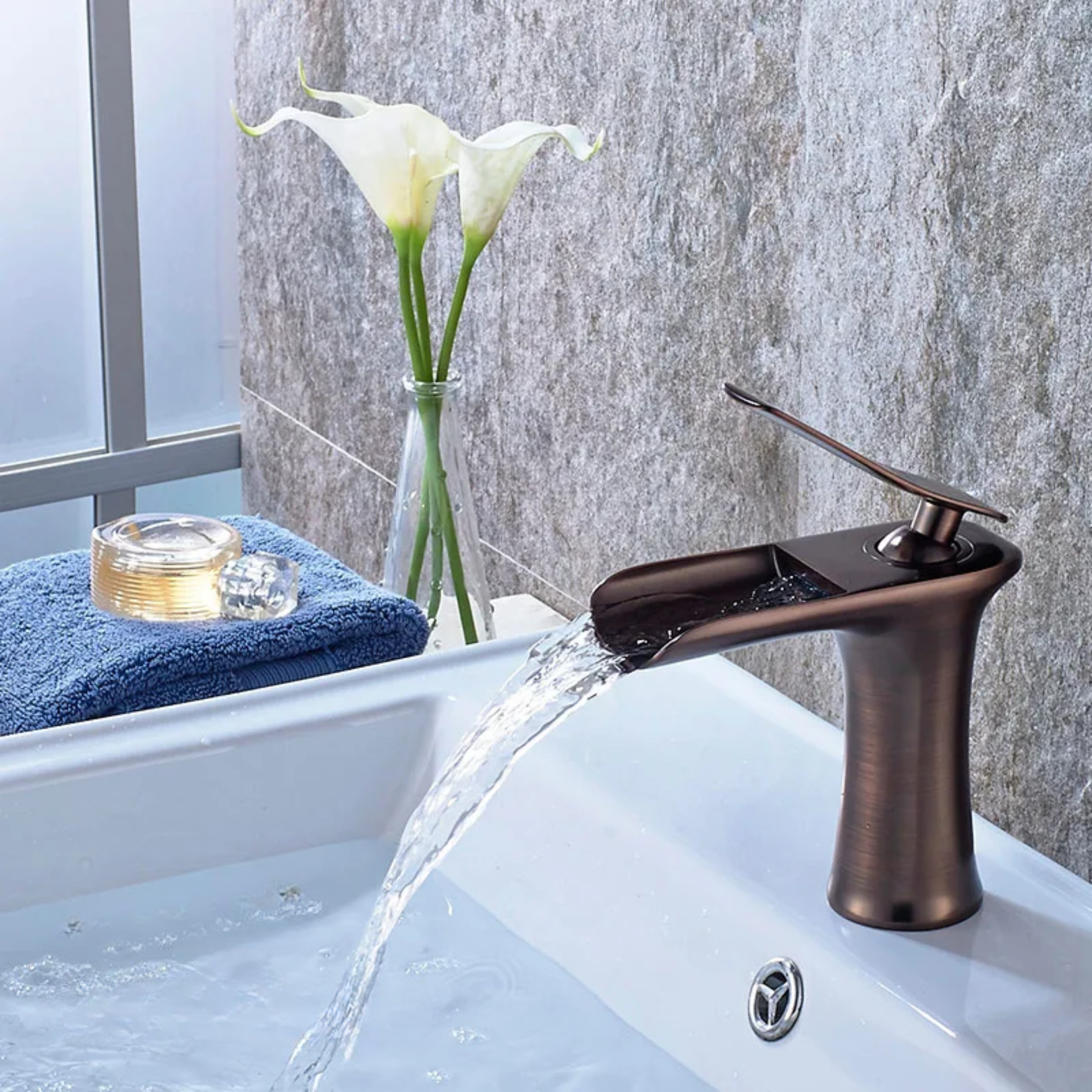 ORB kitchen faucet attached to a sink, featuring a smooth, shiny finish for a modern and elegant look.