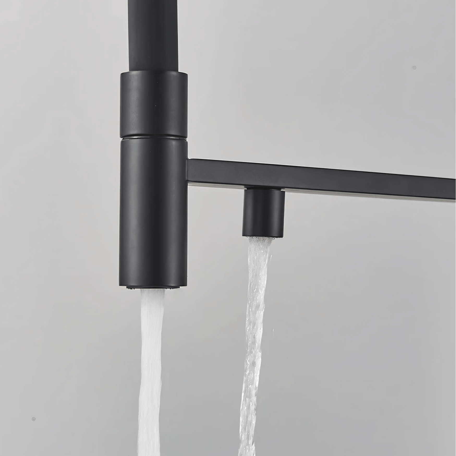 Black faucet with water flowing on a gray background