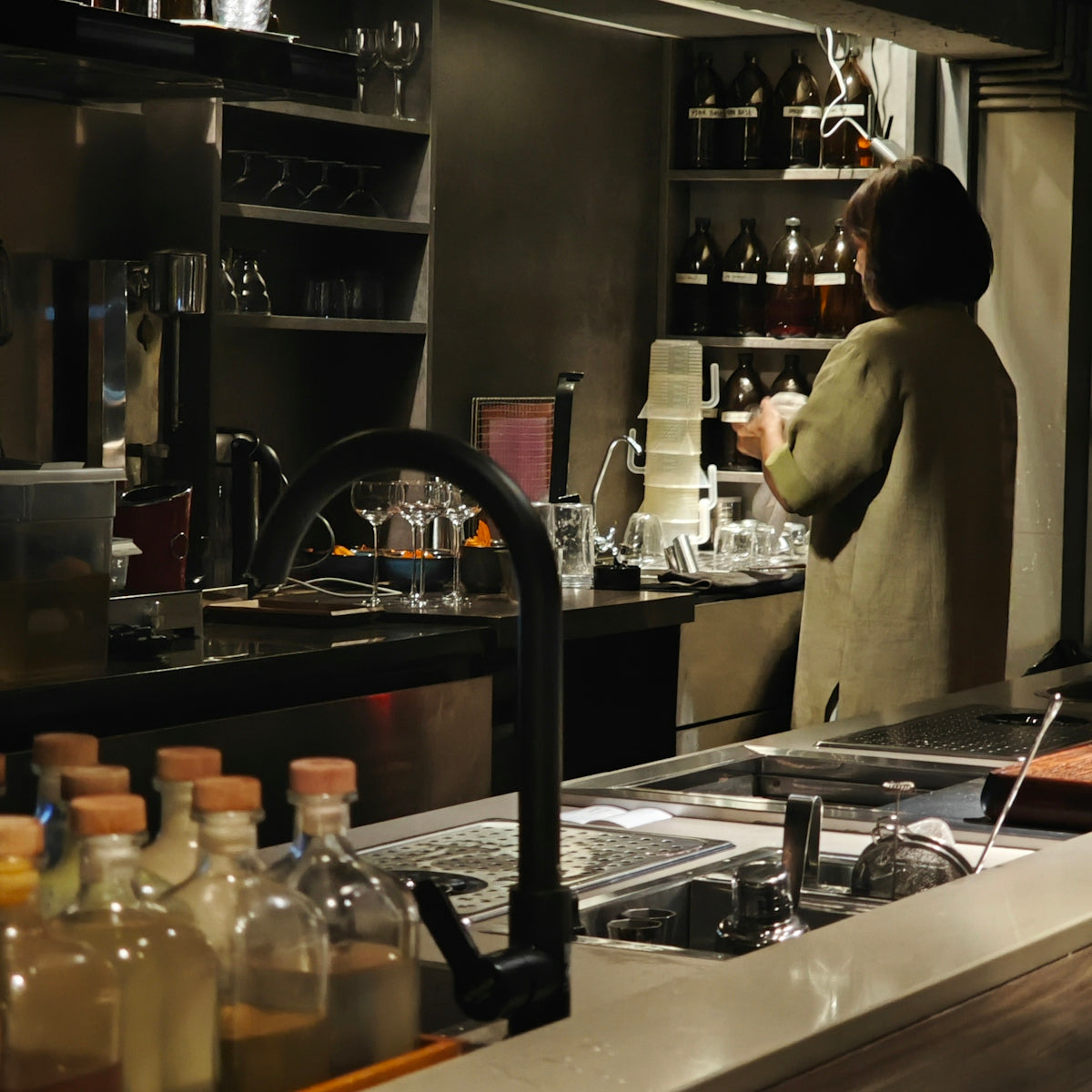 A person is working at a busy bar.