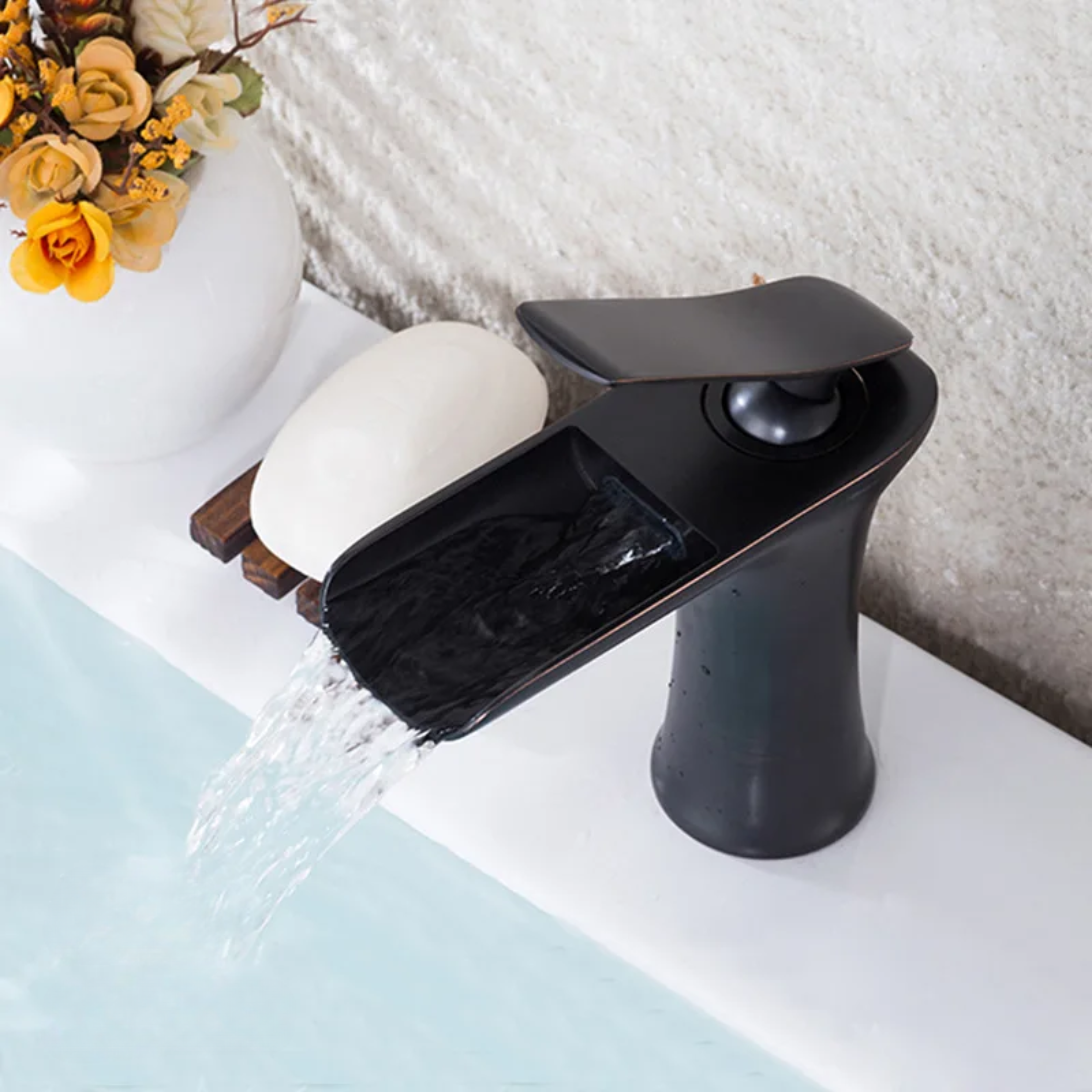 Black kitchen faucet attached to a sink, featuring a smooth, Matte finish for a modern and elegant look.